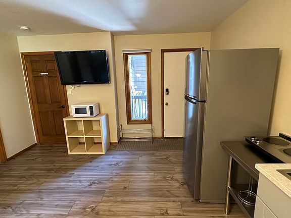 Great room with refrigerator/freezer, 2 burner hot plate, microwave, TV and sink.