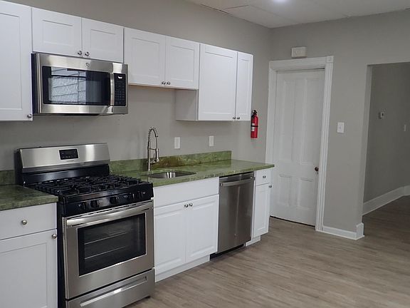 Another view of the kitchen with stainless steel appliances and granite countertop