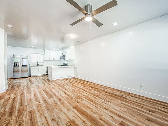Living room with new laminate flooring, LED lighting and TV mount with high end kitchen.