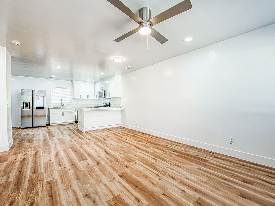 Living room with new laminate flooring, LED lighting and TV mount with high end kitchen.