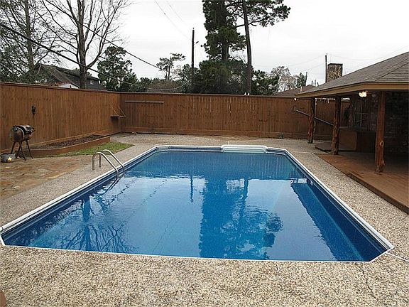 Picturesque backyard boasts large in-ground pool.