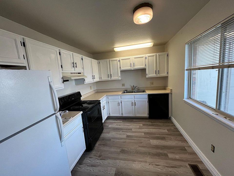 Beautiful newly painted kitchen cabinets with modern sleek black handles for easy open and close.