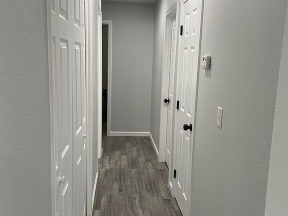 Hallway with washer/dryer unit to left and linen closet to the right