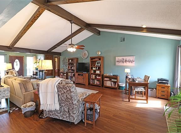 Living Room from Casual Dining area:  Rough beams covered for smooth, easy to clean accent in Vaulted Living Room.