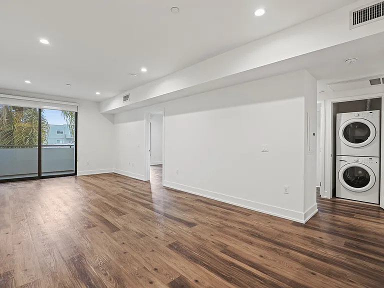 Living and Dining Room Area with an In-Suite Washer/Dryer Located off the Hallway