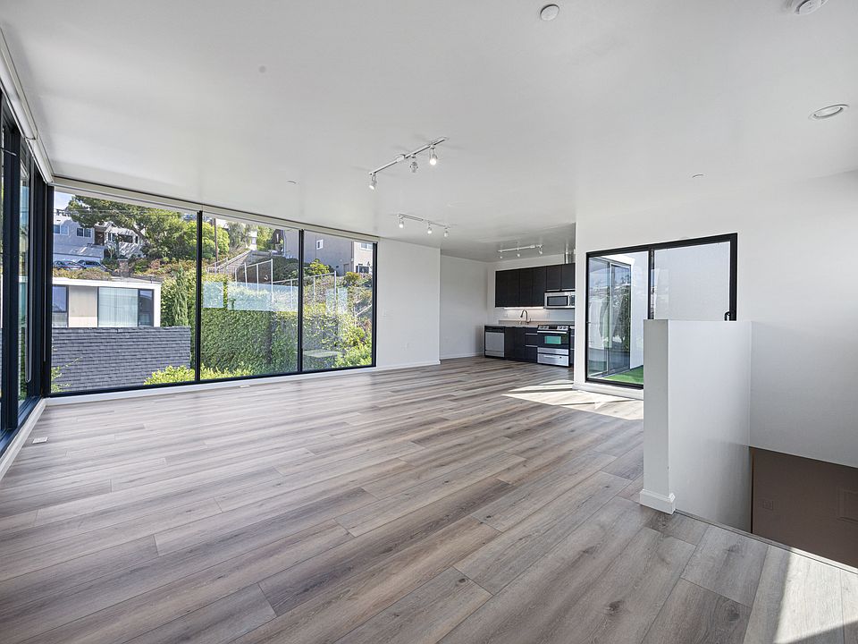Bright open-concept living, dining, and kitchen space with new modern floor-to-ceiling blackout curtains for a sleek and comfortable finish.