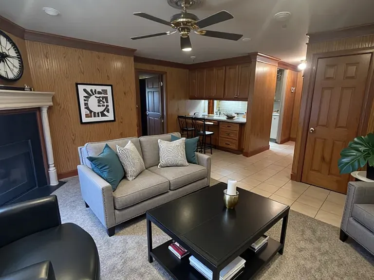 Apt 2A Living room with gas log fireplace and custom mantle, dining area with room for small table or bar stools.