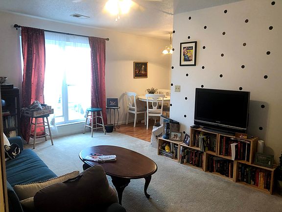 Spacious Living with Natural Light
Bright room with large windows, neutral carpet, and a fun accent wall_ideal for relaxing or entertaining.
