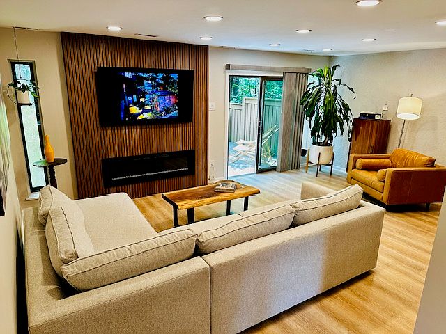 The living room is a serene retreat, featuring acoustic wood panels that not only elevate the design but also enhance sound quality_perfect for relaxing, entertaining, or enjoying music and movies. Large windows and glass doors offer a stunning view.