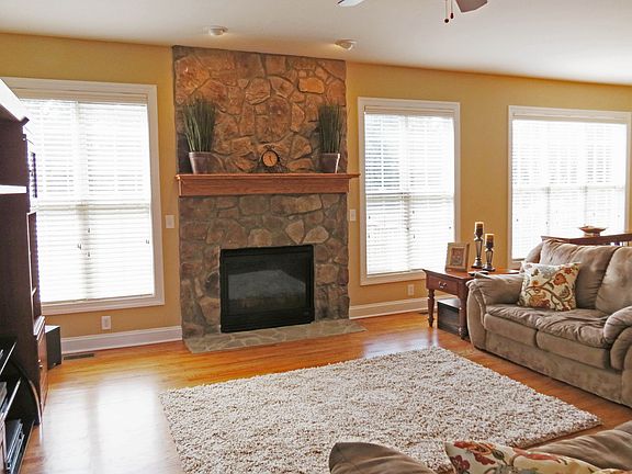 Large family room with stone fireplace is open to the kitchen.