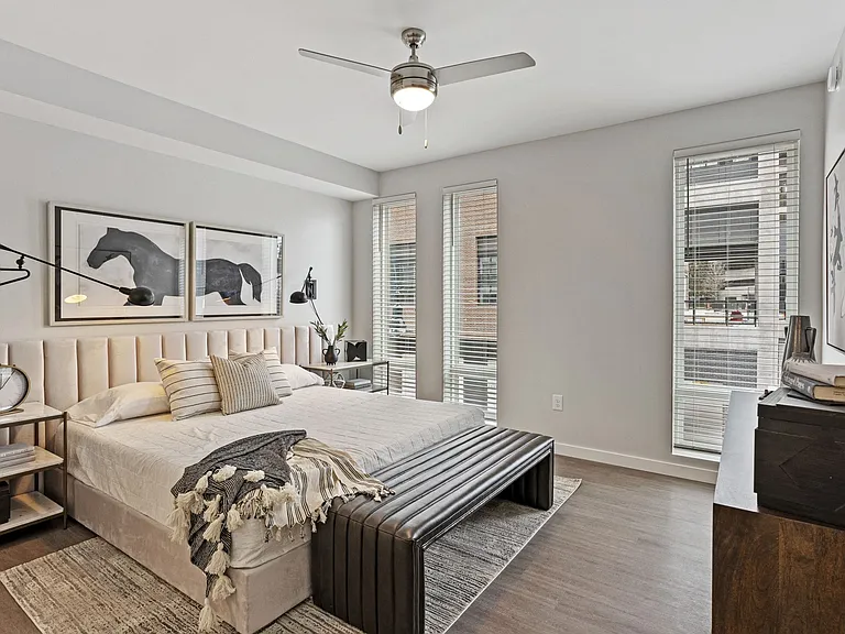 Spacious Bedroom With Ceiling Fan And Large Windows