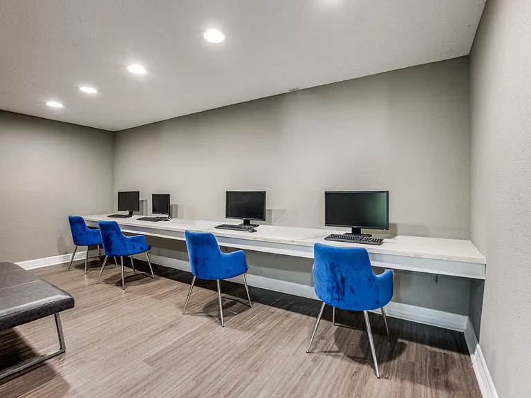 Business center with four open computers for resident use