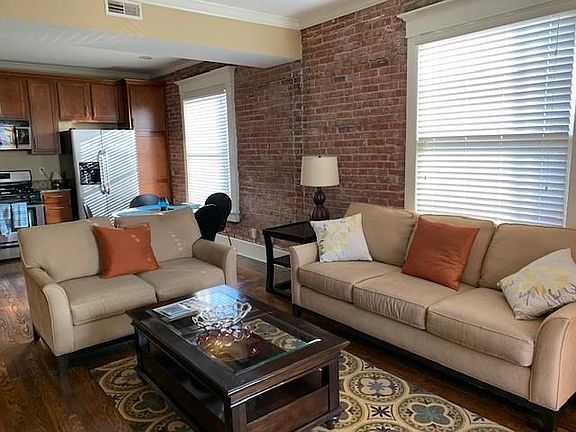 Open concept LR, DR, & Kit; brick wall