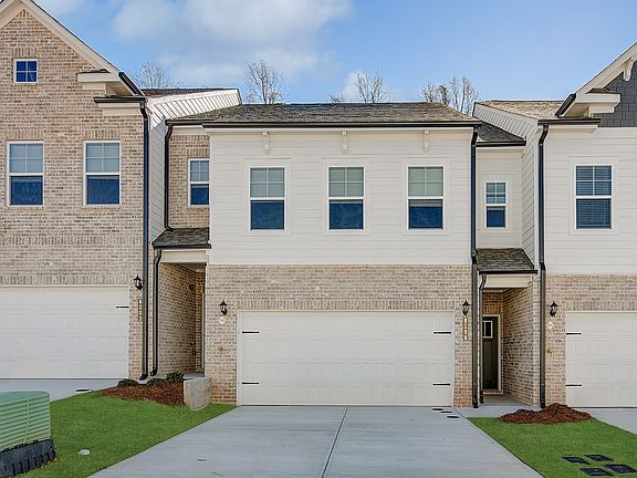 New construction townhome with James Hardie plank siding and brick detailing in townhome community i