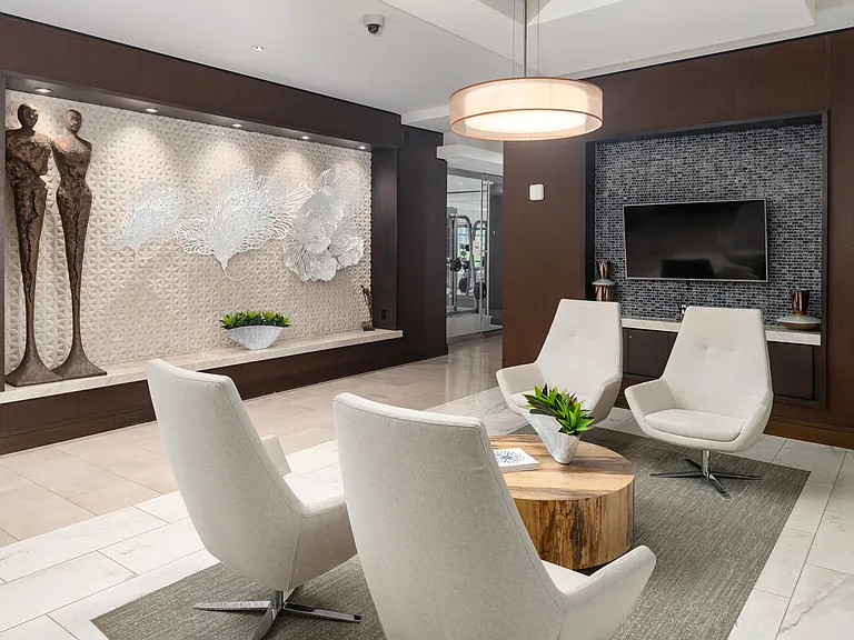 Apartment Lobby with Contemporary Seating, Sculptural Wall Art, and Mounted TV