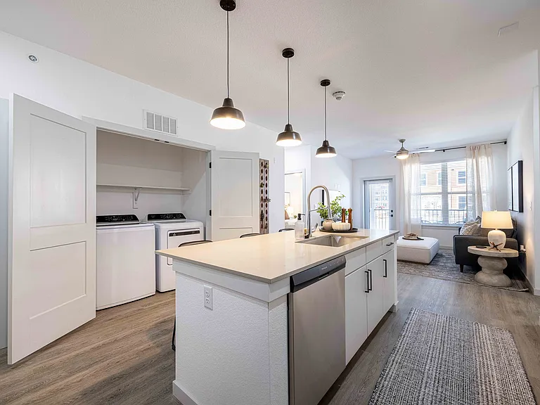 The Garrett Parker B1 floor plan includes a full size side by side washer and dryer in a dedicated closet just off the kitchen.