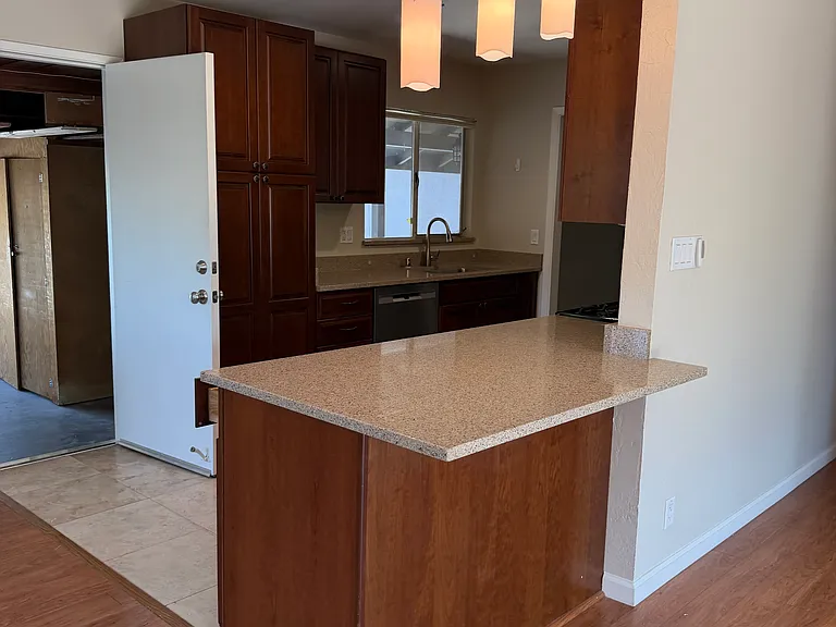 galley kitchen view, with access to garage, pendant lights
