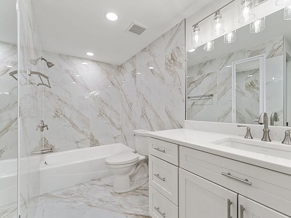 New porcelain tiles grace the floor and walls of this completely renovated bathroom