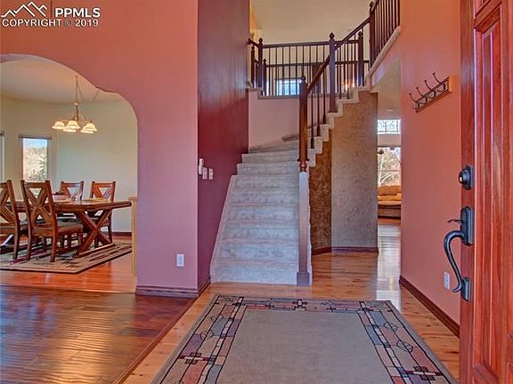 Entryway from front door looks into the living room on the left and dining room beyond. There are gorgeous hardwood floors throu