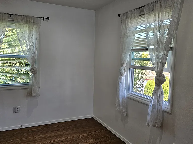 Corner of front room, highlighting two windows.