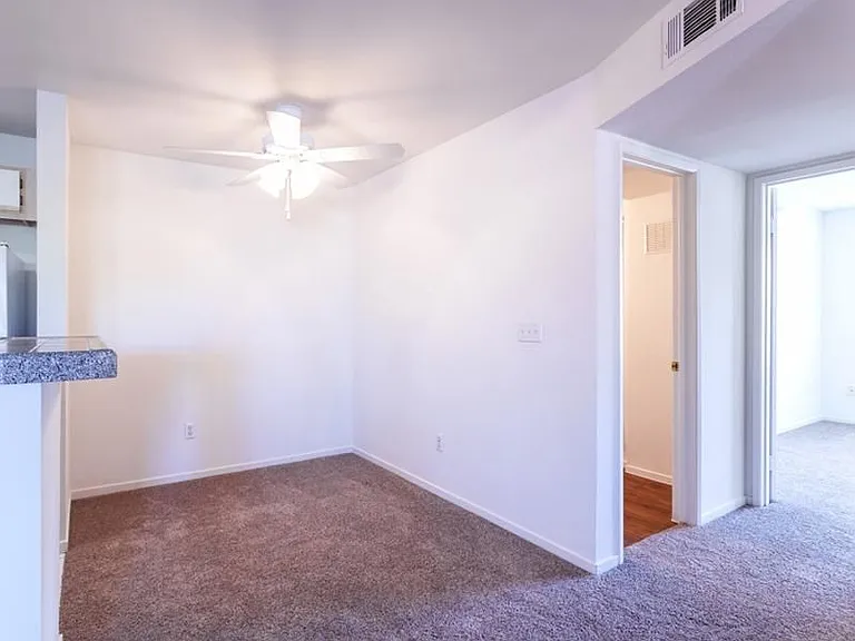 Apartment dining area with door to bathroom and bedroom.