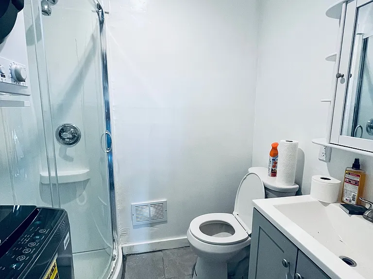 Full bath with corner shower and washer and dryer.