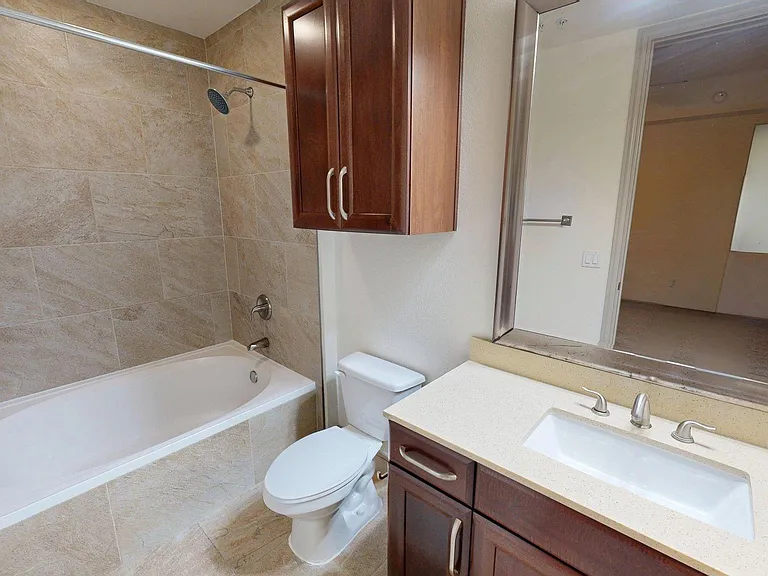 Apartment Bathroom with large soaking tub, vanity mirror and Wood-Style Flooring.