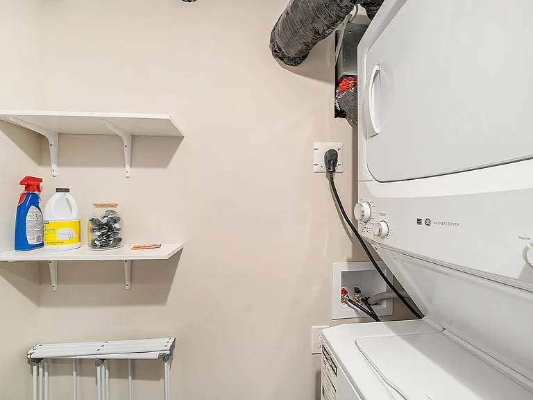 Efficient laundry setup and extra storage shelves in our Ottawa furnished rental.