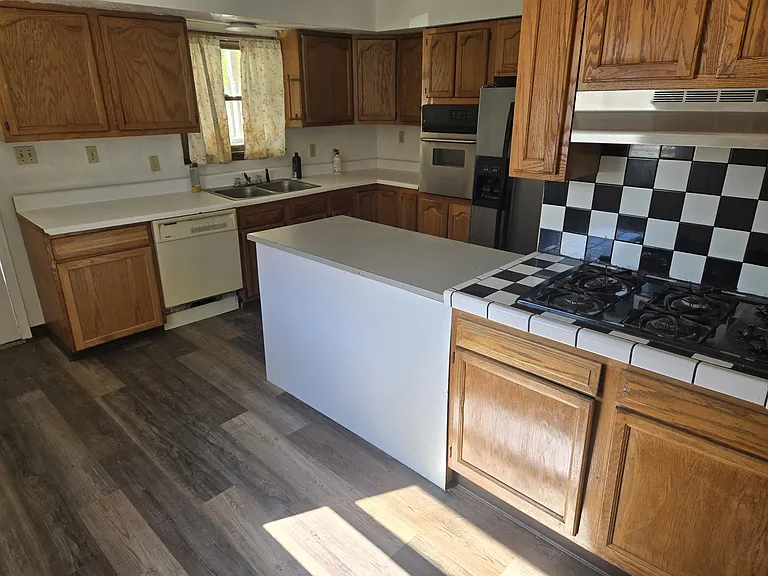 kitchen with stove top, dishwasher, oven and refrigerator/freezer