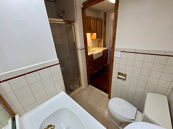 Simple studio layout with living space connecting to galley kitchen, to bathroom.