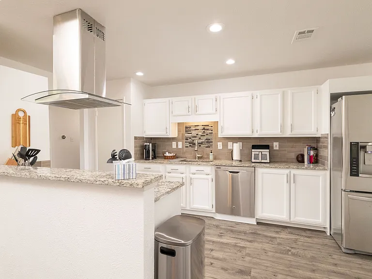Spacious kitchen with a versatile coffee machine (pod or karaffe) including filters and K-cups ready for your morning brew, filtered water/ice and an air fryer complemented by a stainless steel appliances_perfectly blending convenience and style.