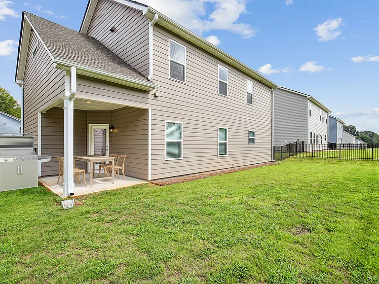 Covered back patio with fenced in yard.