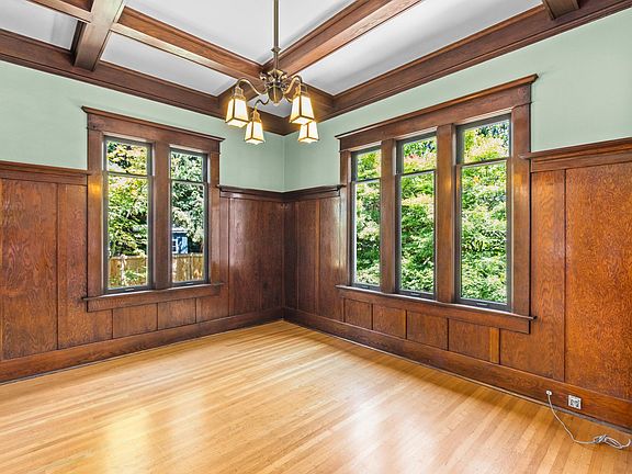 Formal dining room with boxbeam ceiling and abundant natural light. Gleaming hardwoods through living room, dining room, hallway and bedrooms.