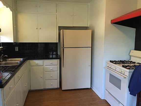 Kitchen with refrigerator and gas stove.