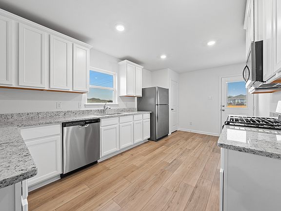 Enjoy stunning granite countertops and designer wood cabinetry in this kitchen.