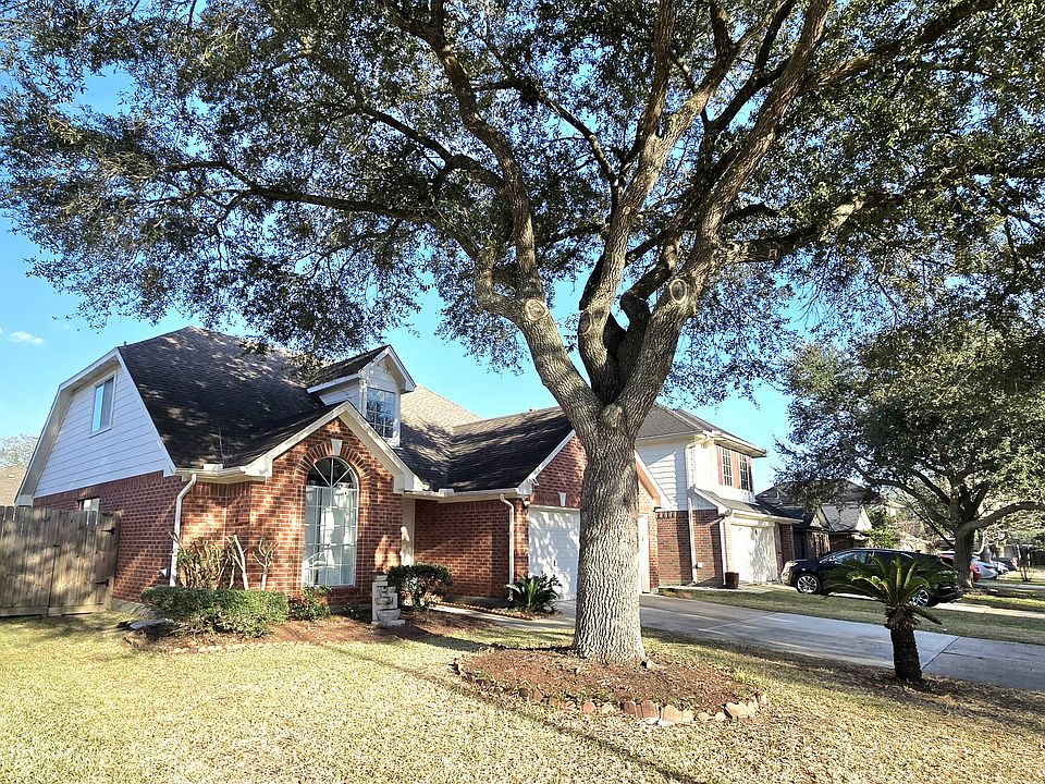 Charming street view of the home, shaded by a large oak tree that offers abundant relief from the summer sun.