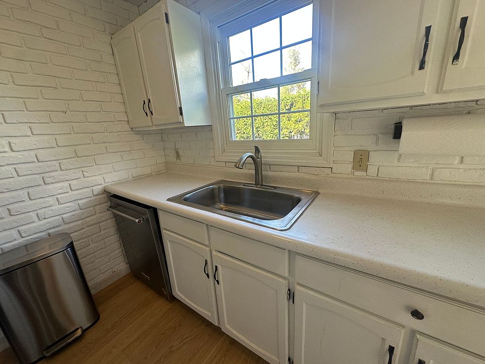 New large sink - easy cleaning of large pans, new stainless steel dishwasher. View out to semi-private lawn shielded from parking lot by privet fence