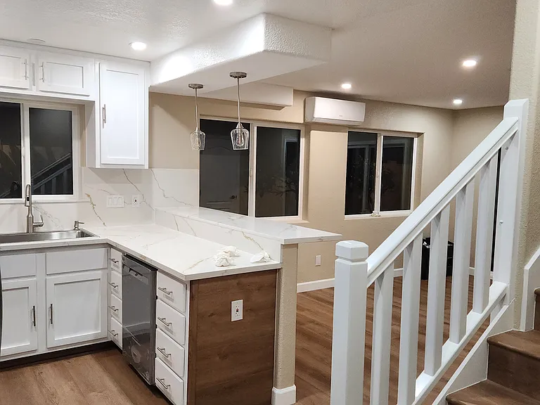 View from front entrance to kitchen area, bar and living room.