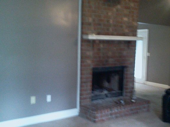 very large open living room with a wood burning fireplace