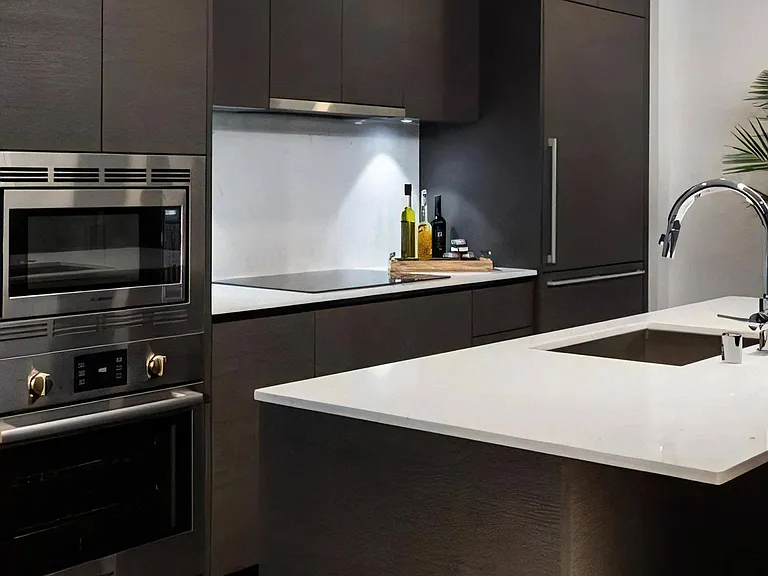Apartment Kitchen with Stainless Steel Appliances and Black Tile Backsplash
