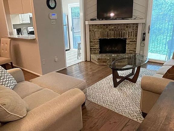 Living Room with hardwood floors and wood burning fireplace; sliders out to patio area