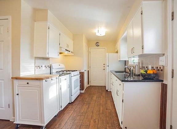 Bright and open galley-type kitchen with hardwood flooring and lots of cabinet space