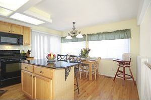 Remodeled kitchen with slab granite counters.