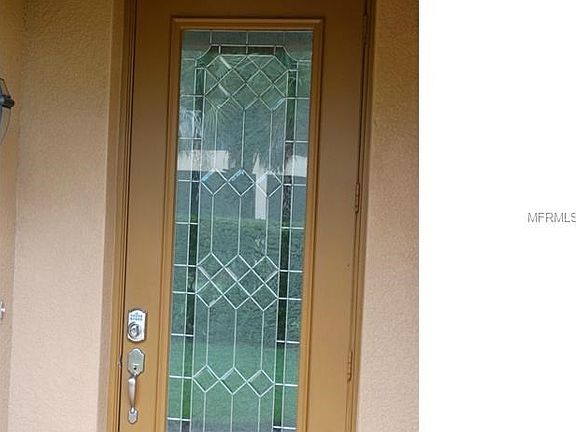 The entry is covered and the door has a leaded glass insert. Note the programmable security lock.