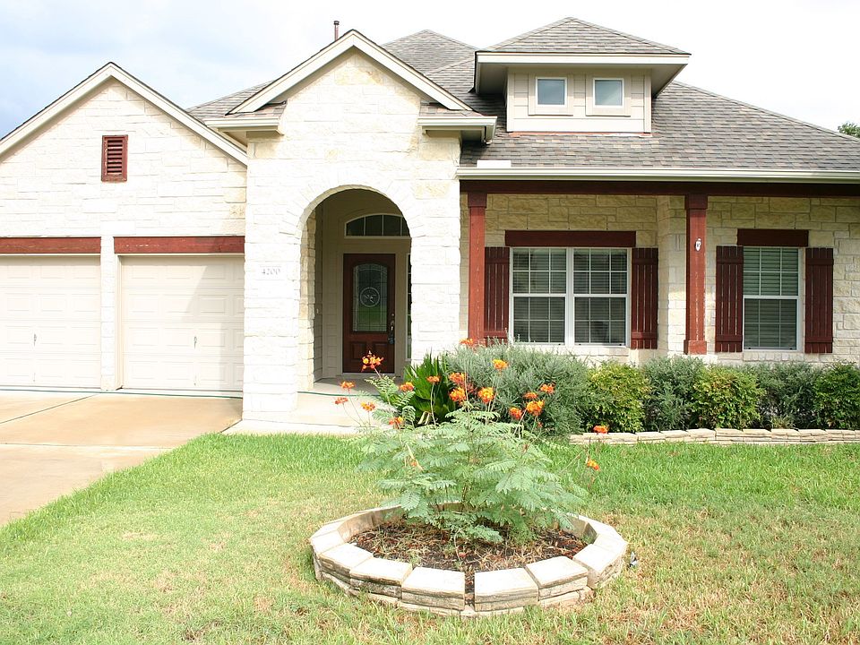 White Stone with wood trim and shutters highlight this home.