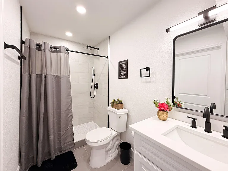 Updated bath with tiled walk-in shower, sleek vanity storage, and matte-black fixtures for everyday convenience.