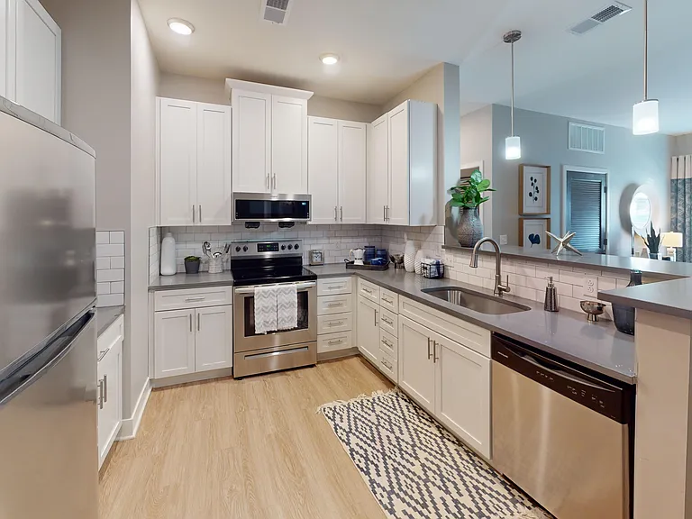 Enjoy cooking in style with stainless steel appliances, bright white cabinets, and plenty of prep space in this modern kitchen.