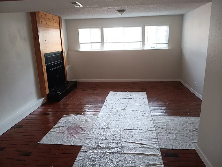 Spacious downstairs recreation room with wood fire place, brick floors and desk space. Separate laundry with washer and dryer just off this room.