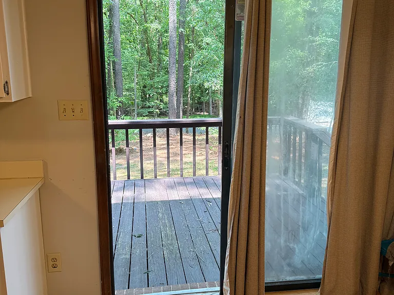 Sliding doors that lead to the back porch and wooded lot.
