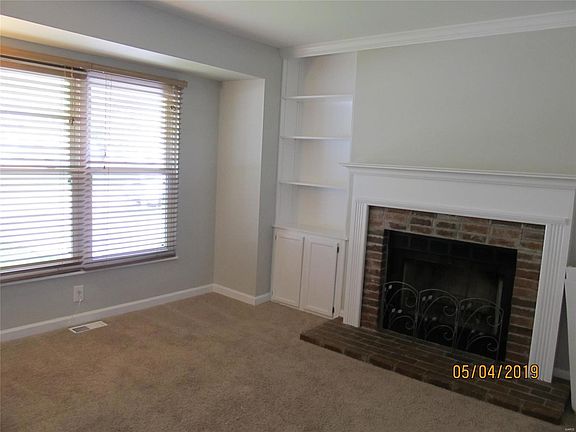 Wood burning fireplace flanked by built in shelves.